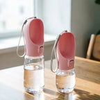 Two pink portable dog water bottles, 550 ml and 350 ml, on a table