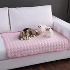 Pink quilted dog cooling mat on a sofa with pets