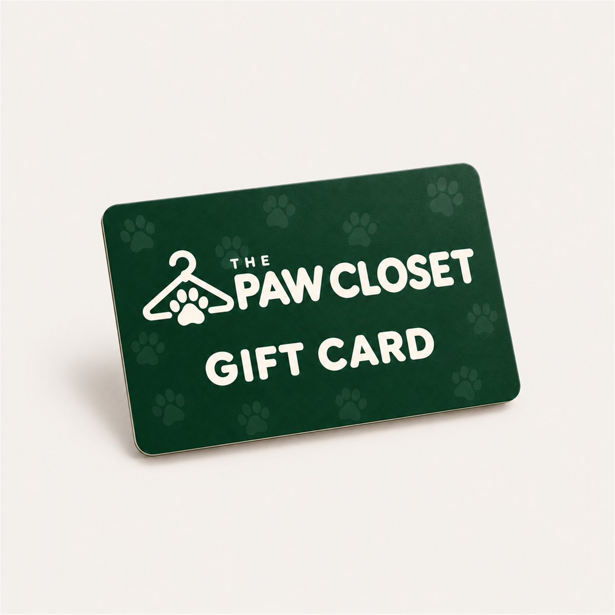 The Paw Closet forest green gift card with cream logo and subtle paw prints on a warm off-white background.